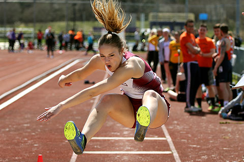 A track athlete competing in the long jump.